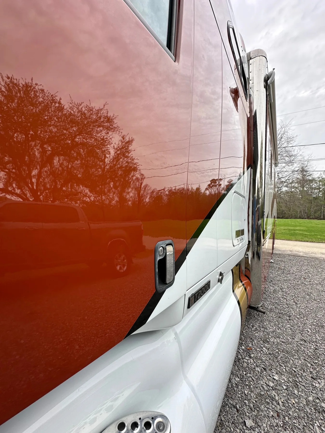Orange specialty coach with mirror-like finish after detailing